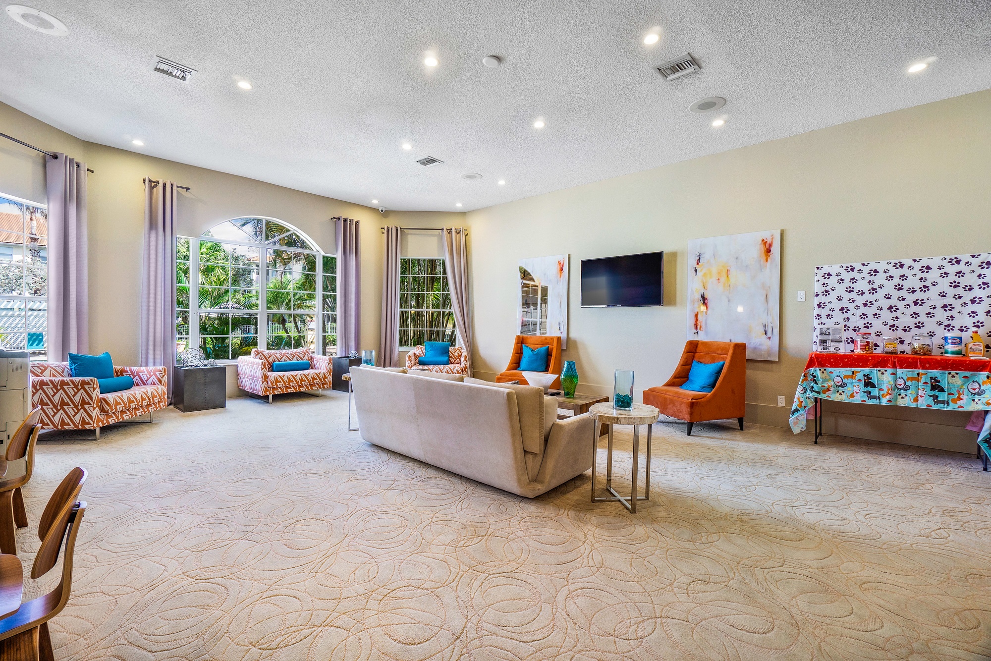 A living room with a sofa, chairs, and a television.